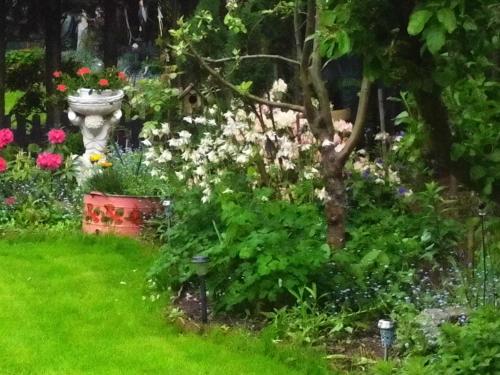 een schilderij van een tuin met bloemen en een standbeeld bij Alteschule15 in Leibsch