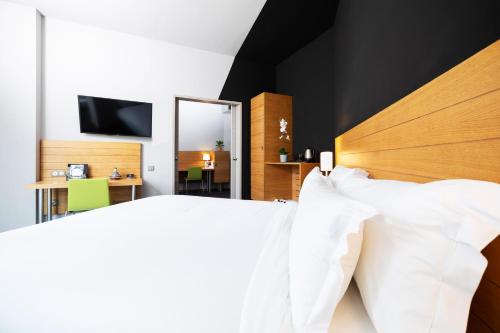 a bedroom with two white beds and a mirror at ONOMO Hotel Casablanca City Center in Casablanca
