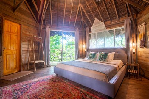 a bedroom with a bed in a room with a window at Selina Red Frog in Bocas del Toro