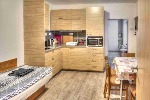 una cocina con armarios de madera y una mesa con comedor. en Apartmány pod Divadlem, en Znojmo