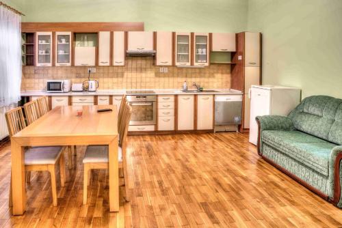 uma cozinha com uma mesa de madeira e um sofá verde em Apartmány pod Divadlem em Znojmo