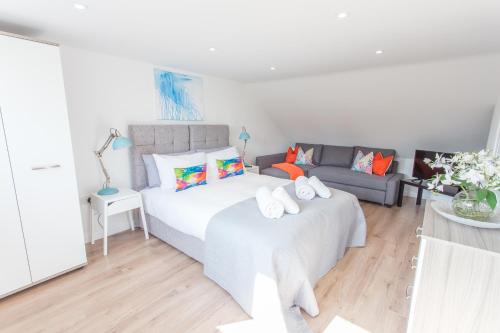 ein Schlafzimmer mit einem Bett und einem Sofa in der Unterkunft Pinnocks Lodge Apts 2 Bed Apts Botley close to A34 in Oxford