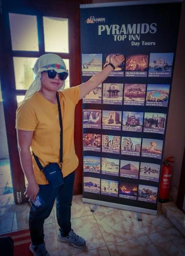 a man is standing in front of a sign at Pyramids Top Inn in Cairo