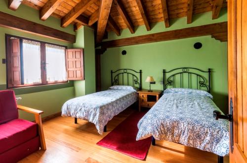 1 dormitorio con 2 camas y sofá rojo en Centro de Turismo Rural La Coruja del Ebro, en Valderredible