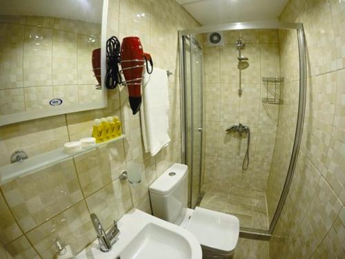 y baño con ducha, aseo y lavamanos. en Taksim Square Apart Hotel, en Estambul