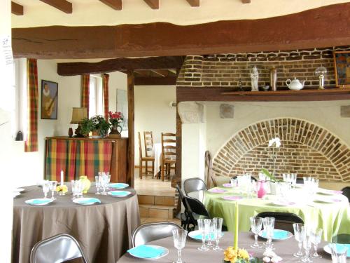 uma sala de jantar com duas mesas com toalha de mesa verde em Maison de 4 chambres avec jardin amenage et wifi a Berville em Berville