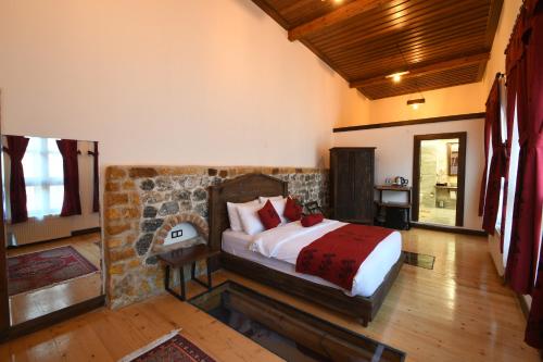 a bedroom with a bed and a stone wall at Yazmacılar Hanı Otel Restaurant in Tokat