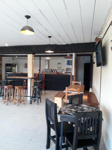 ein Esszimmer mit Tischen und Stühlen und eine Bar in der Unterkunft Mistico Hostel 23 in El Chalten