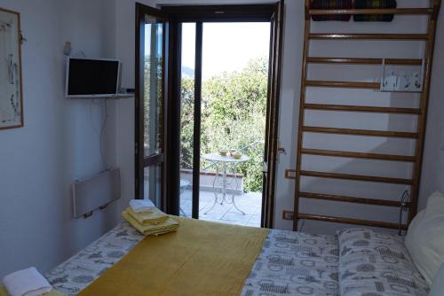 a bedroom with a bed and a door to a patio at Camera vista mare, ingresso indipendente in" Villa VìVì" in Siniscola