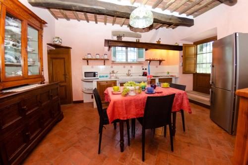 a kitchen with a table with a red table cloth at Villa al Borghetto in Uzzano