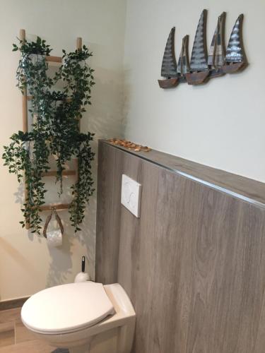 a bathroom with a toilet and plants on the wall at Heimat am Meer in Büsumer Deichhausen