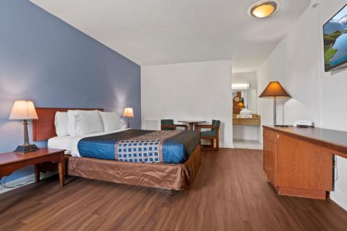 a hotel room with a bed and a desk and a room at Economy Lodge Portsmouth in Portsmouth