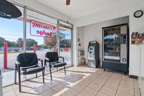 a store with three chairs in front of a window at Economy Lodge Portsmouth in Portsmouth