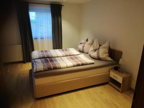 una cama con almohadas y una ventana en una habitación en Haus Manfred, en Sankt Jakob in Haus
