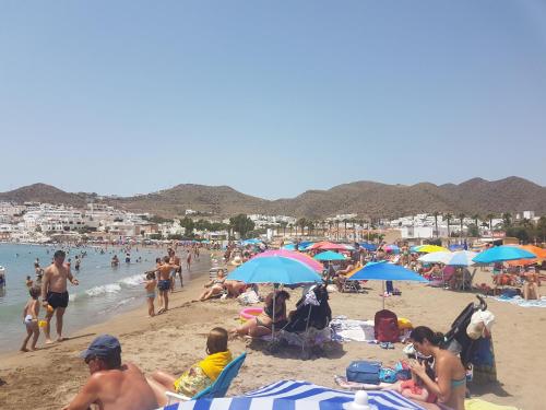 a crowd of people on a beach with umbrellas at CASA BLANCA Apartments SAN JOSE in San José