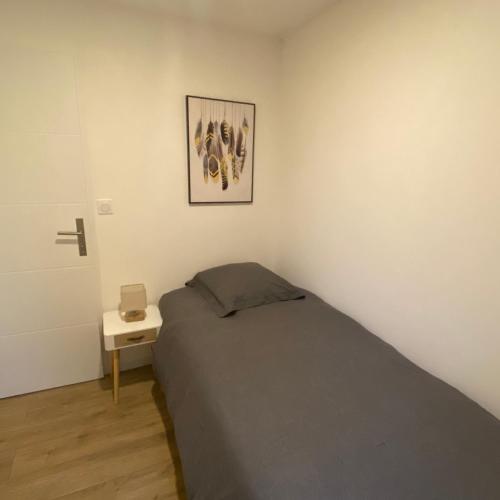 une chambre avec un lit et un tableau au mur dans l'établissement Les Troglodytes du Ventoux, à Bollène