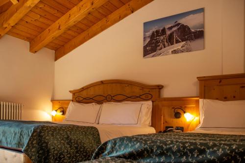 a bedroom with two beds and a mountain at Hotel Garnì La Soldanella in Madonna di Campiglio