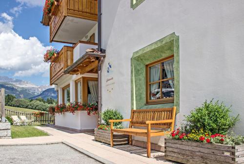 a wooden bench sitting outside of a building at Hotel Garnì La Soldanella in Madonna di Campiglio