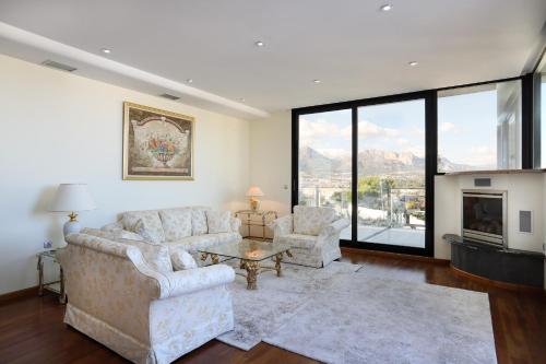 a living room with a couch and chairs and a fireplace at DREAM VILLA IN ALBIR BLUELINE in L'Alfas del Pi