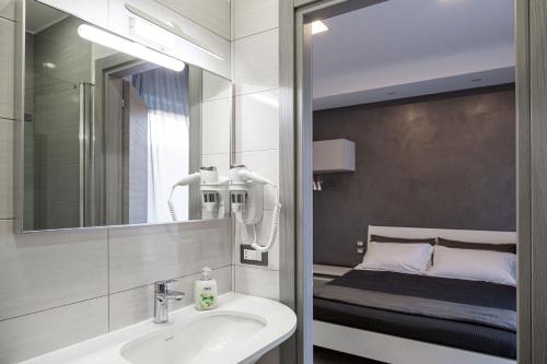 a bathroom with a sink and a mirror and a bed at Amica geniale in Naples