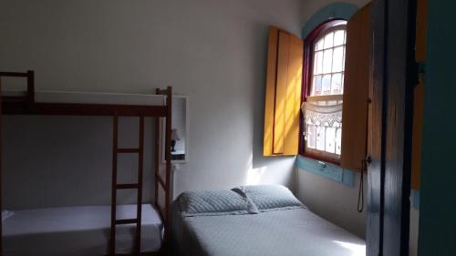 a bedroom with two bunk beds and a window at Hostel Imperial in Ouro Preto