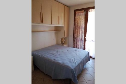 a small bedroom with a bed and a window at Appartamento sulla Laguna in Orbetello