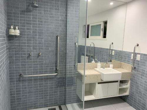 ピパにあるApartamento moderno e totalmente acessívelの洗面台と鏡付きシャワーを備えたバスルーム