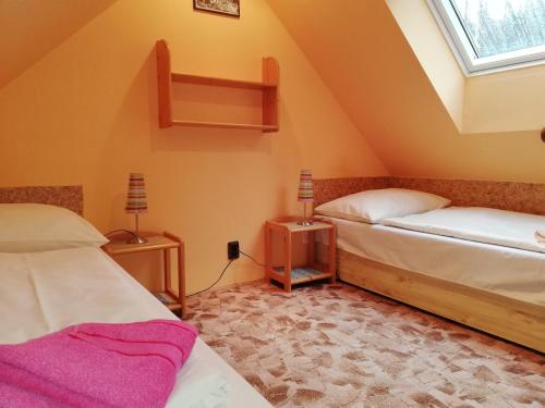 a attic room with two beds and a window at Pension Vladimír in Janske Lazne