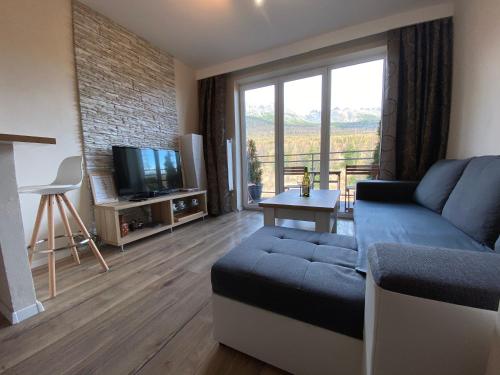ein Wohnzimmer mit Couch und Fernseher in der Unterkunft Apartmán pod Gerlachovským štítom in Vysoké Tatry