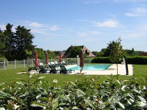 une piscine avec des chaises longues et une maison dans l'établissement Les BALCONS de L'ESPERANCE, à Limeuil