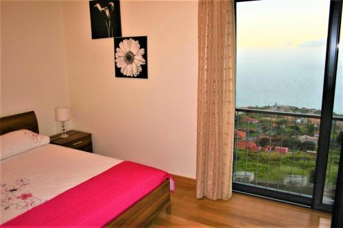 Un dormitorio con una cama y una ventana grande. en The Rose House, en Arco da Calheta
