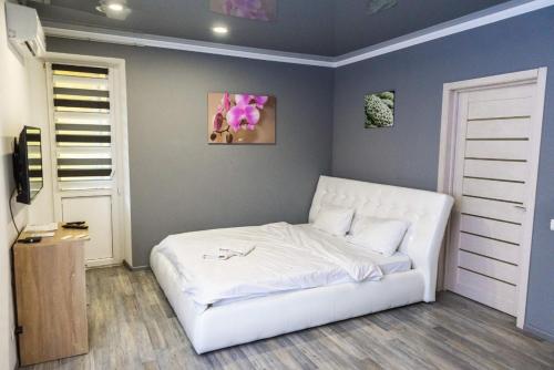 een slaapkamer met een wit bed in een kamer bij Cozy apartment in a new building close to the downtown in Kiev