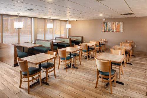 a dining room with wooden tables and chairs at Quality Inn & Suites Windsor - Downtown in Windsor