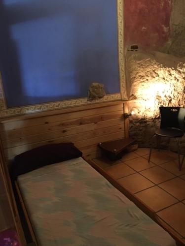 a small room with a bed and a blue wall at Monolocal rural con encanto in Valbona