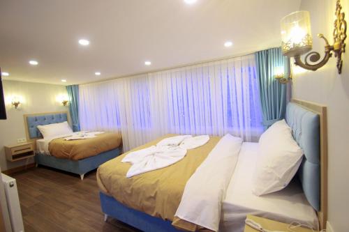a hotel room with two beds and a window at Hira Hotel in Istanbul