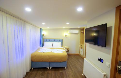 a bedroom with a bed and a flat screen tv at Hira Hotel in Istanbul