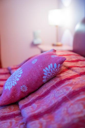 a bed with two pink pillows on it at Yiannis Apartments in Ioannina