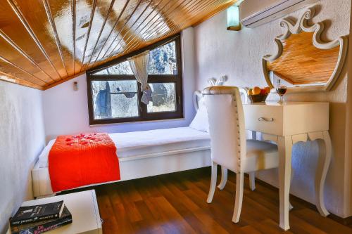 een kamer met een bed, een bureau en een raam bij Kekova Theimussa in Kaleucagız