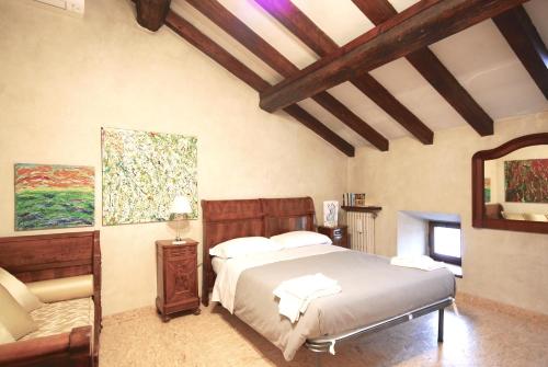 a bedroom with a bed and a chair and a mirror at Casa del Pittore in Mantova