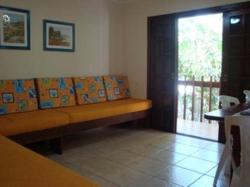 a living room with a bench with pictures on it at Budget Apartamento Na Praia Ubatuba in Ubatuba