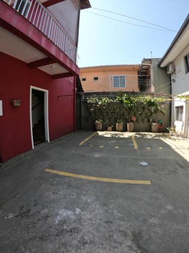 a parking lot with a red building and a garage at Morada da Marta in Guarda do Embaú