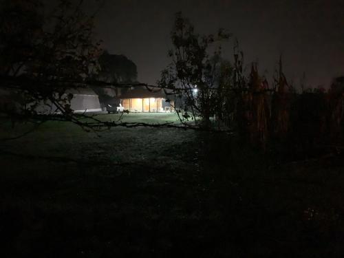 a house lit up at night with a fence at Cabañas Los Abuelos in Zacatlán