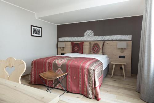 a bedroom with a large bed with red and white blankets at Hotel Steffani in St. Moritz