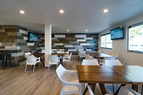 a restaurant with tables and white chairs in a room at Hotel Star in Manzanillo