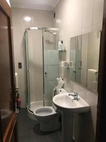 een badkamer met een douche, een toilet en een wastafel bij Hostal imperio in Tomelloso