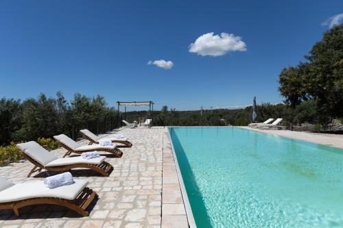 una fila di sedie a sdraio accanto alla piscina di Tenuta Regina a Castrignano del Capo