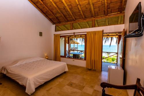1 dormitorio con cama y vistas al océano en Balihai Bungalows en Canoas de Punta Sal