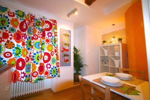 a dining room with a table and a colorful curtain at Piazza Grande City Residence in Trieste