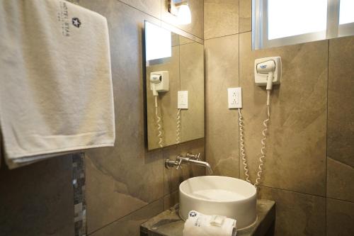 y baño con lavabo, espejo y aseo. en Hotel Star, en Manzanillo