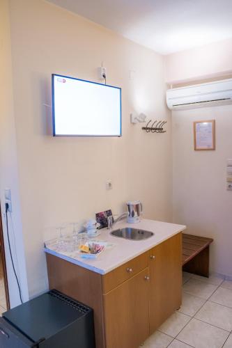 a bathroom with a sink and a screen on the wall at Yiannis Apartments in Ioannina